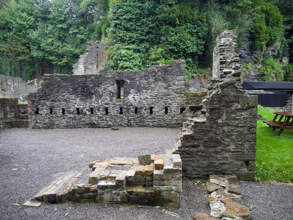 Partially collapsed brick walls that outline a room.